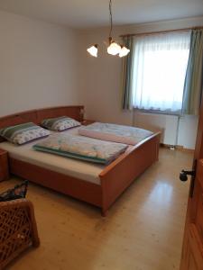 Un dormitorio con una cama grande y una ventana en Ferienhof Murr, en Thurmansbang