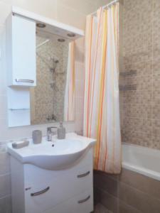 a bathroom with a sink and a shower curtain at Apartments Sunrise in Tivat