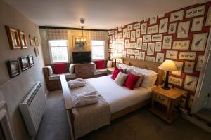 a bedroom with a large bed and a wall of pictures at The Highway Inn in Burford