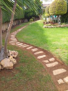 een geplaveid pad in een tuin met een palmboom bij Residence L' Aubrais in Limassol