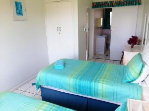 a bedroom with two twin beds and a bathroom at Claridges 302 in Margate
