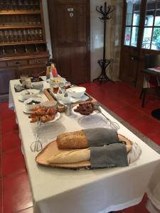 una mesa blanca con comida encima en LA FERME DE LA HUPPE, en Gordes