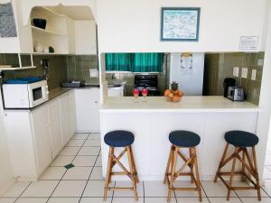 a kitchen with two bar stools and a counter at Claridges 302 in Margate
