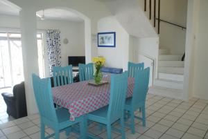 a dining room with a table and blue chairs at Rosscarbery 6 in Margate