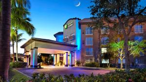 a hotel exterior at night with a moon in the sky at Holiday Inn Express & Suites Naples Downtown - 5th Avenue by IHG in Naples
