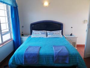 a bedroom with a bed with a blue blanket and pillows at Southern Comfort - Starfish in Margate