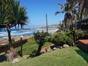 a view of a beach with palm trees and a house at Southern Comfort - Starfish in Margate +16 photos