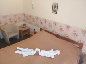 a bedroom with a bed with two white towels on it at Hotel Hajnal in Mezőkövesd