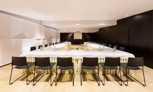 une salle de conférence avec une grande table blanche et des chaises dans l'établissement Hotel Fernando III, à Séville