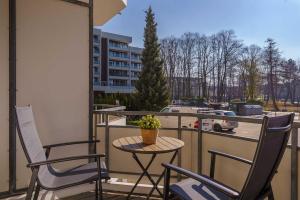 a patio with two chairs and a table on a balcony at Das Meer Genie En in Scharbeutz