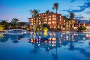 a pool in front of a hotel at night at The Norm Oriental Kemer in Kemer