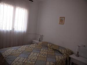 ein Schlafzimmer mit einem Bett mit einer Decke darauf in der Unterkunft ROSES 4 in Roses