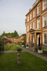 un gran edificio de ladrillo con un jarrón en el césped en Middlethorpe Hall & Spa en York