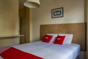 ein Schlafzimmer mit einem Bett mit zwei roten Kissen in der Unterkunft Palace Hotel Campo Grande in Campo Grande