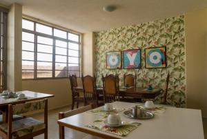 ein Esszimmer mit Tischen, Stühlen und einem Fenster in der Unterkunft Palace Hotel Campo Grande in Campo Grande