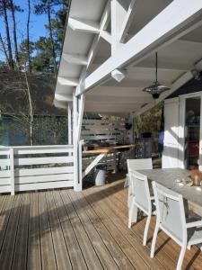 a patio with a table and chairs on a wooden deck at Domaine résidentiel naturiste de la Jenny chalet 6 pers in Le Porge