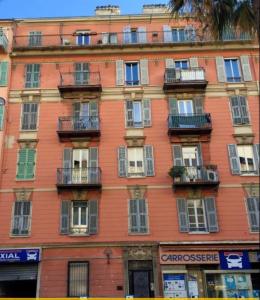 duży pomarańczowy budynek z oknami i balkonami w obiekcie Studio plein coeur de Nice 24 24H 7 7J w Nicei