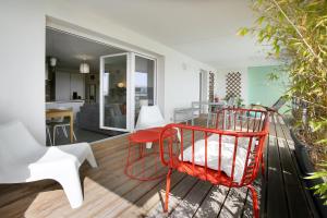uma cadeira vermelha sentada no convés de uma casa em expat renting - Le Mosaïque - Patte d'Oie - Parking em Toulouse