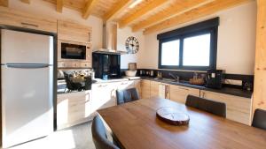 a kitchen with a wooden table and a dining room at Le Chalet de Juliette in Besse-et-Saint-Anastaise