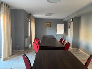 a conference room with wooden tables and red chairs at Hotel Marta in Oława
