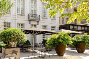 eine Außenterrasse mit Tischen und Stühlen sowie ein Gebäude in der Unterkunft Pillows Grand Boutique Hotel Reylof Ghent in Gent
