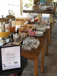 a table with plates and glasses on top at La Playa Orient Bay in Orient Bay