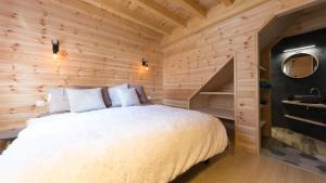 a bedroom with a bed in a wooden wall at Le Chalet de Juliette in Besse-et-Saint-Anastaise