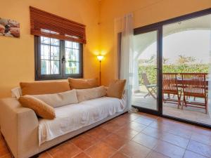 a living room with a white couch and a patio at Holiday Home Ducados Golf by Interhome in Pals