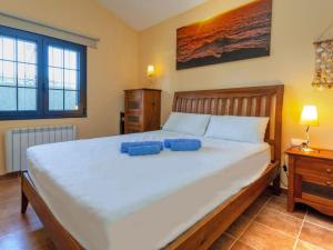 a bedroom with a large bed with two blue pillows on it at Holiday Home Ducados Golf by Interhome in Pals +15 photos