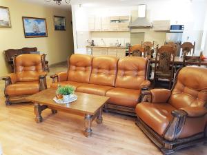 a living room with leather furniture and a table at Balaton Rowy in Rowy