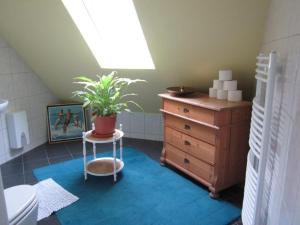 a bathroom with a dresser and a potted plant at ARTEP 73 Gästewohnung in Bremen