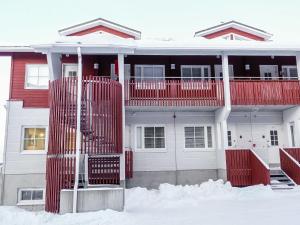 ein Haus mit einem roten Zaun im Schnee in der Unterkunft Holiday Home Levi star i- ap-1110 by Interhome in Sirkka