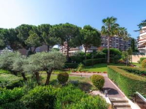 een tuin met bomen en struiken en een gebouw bij Apartment Le Provence by Interhome in Vallauris