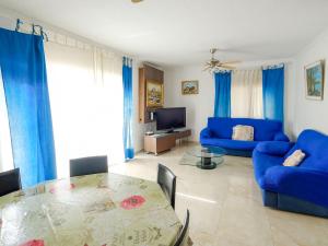 uma sala de estar com um sofá azul e uma mesa de vidro em Villa Uno by Interhome em L'Ametlla de Mar