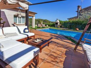 un patio trasero con piscina y una villa en Holiday Home Lumiere by Interhome, en Sant Antoni de Calonge