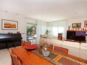 a living room with a white couch and a piano at Holiday Home Lumiere by Interhome in Sant Antoni de Calonge