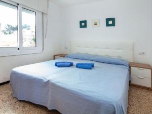 a bedroom with a bed with blue pillows on it at Apartment Blue Ocean-3 by Interhome in Llança