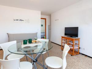 sala de estar con mesa de cristal y sillas blancas en Apartment Blue Ocean-3 by Interhome, en Llançà