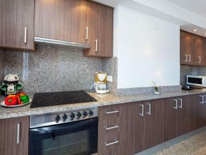 a kitchen with wooden cabinets and a stove top oven at Apartment Blue Ocean-3 by Interhome in Llança