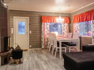 ein Esszimmer mit einem Tisch und Stühlen in einem Raum in der Unterkunft Holiday Home Jäkälätieva by Interhome in Raattama