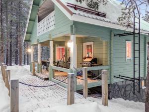 Holiday Home Jäkälätieva by Interhome في Raattama: منزل أخضر مع سطح في الثلج