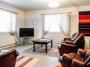 a living room with leather chairs and a tv and a table at Holiday Home Tieva by Interhome in Peltovuoma