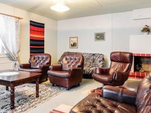 a living room with leather furniture and a fireplace at Holiday Home Tieva by Interhome in Peltovuoma