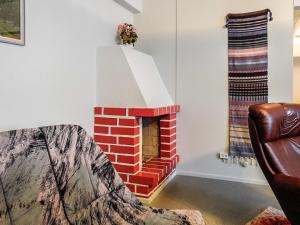 a brick fireplace in a living room with a couch at Holiday Home Tieva by Interhome in Peltovuoma