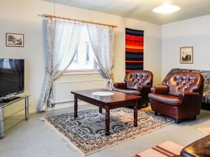 a living room with leather chairs and a table and a tv at Holiday Home Tieva by Interhome in Peltovuoma