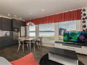 a kitchen and dining room with a table and a television at Holiday Home Viljami by Interhome in Kaustinen