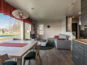 eine Küche und ein Wohnzimmer mit einem Tisch und einer Couch in der Unterkunft Holiday Home Viljami by Interhome in Kaustinen + 13 Fotos