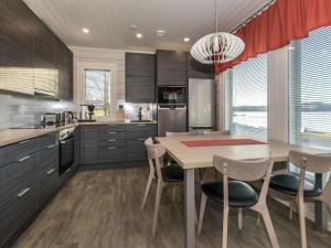 eine Küche mit Holztisch und Stühlen und ein Esszimmer in der Unterkunft Holiday Home Viljami by Interhome in Kaustinen