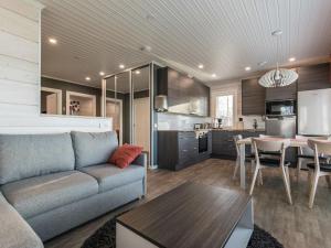 ein Wohnzimmer mit einem Sofa und einem Tisch sowie eine Küche in der Unterkunft Holiday Home Viljami by Interhome in Kaustinen