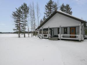 a small house in the snow with trees in the background at Holiday Home Suvituuli by Interhome in Pertunmaa